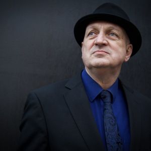 Head and shoulders monochrome image of Paul Pace looking upwards